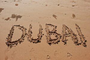 "Dubai" written in the sand on the beach